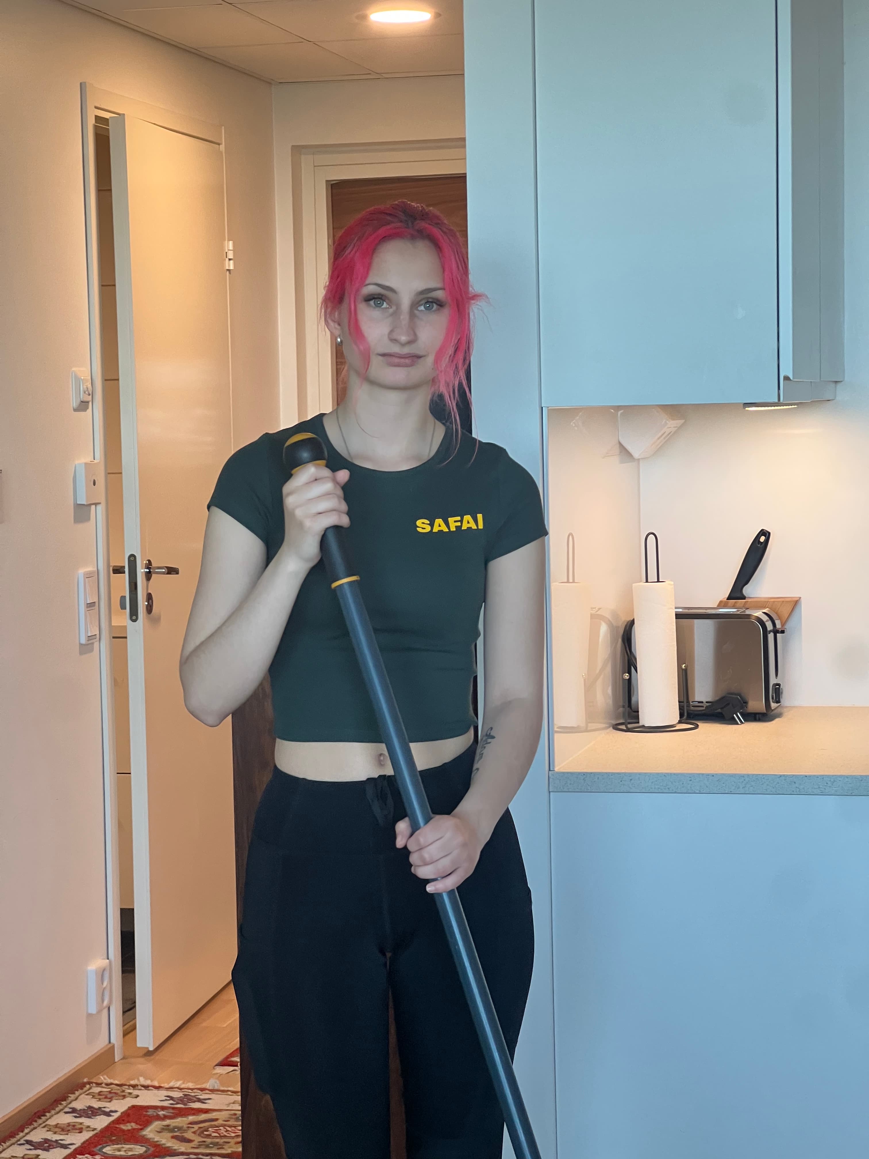 Safain siivooja valmistautuu siivoamaan modernin keittiön ammattilaistason välineillä.